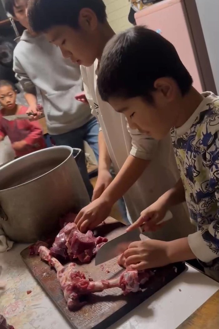 お肉を切って料理をする子どもたち